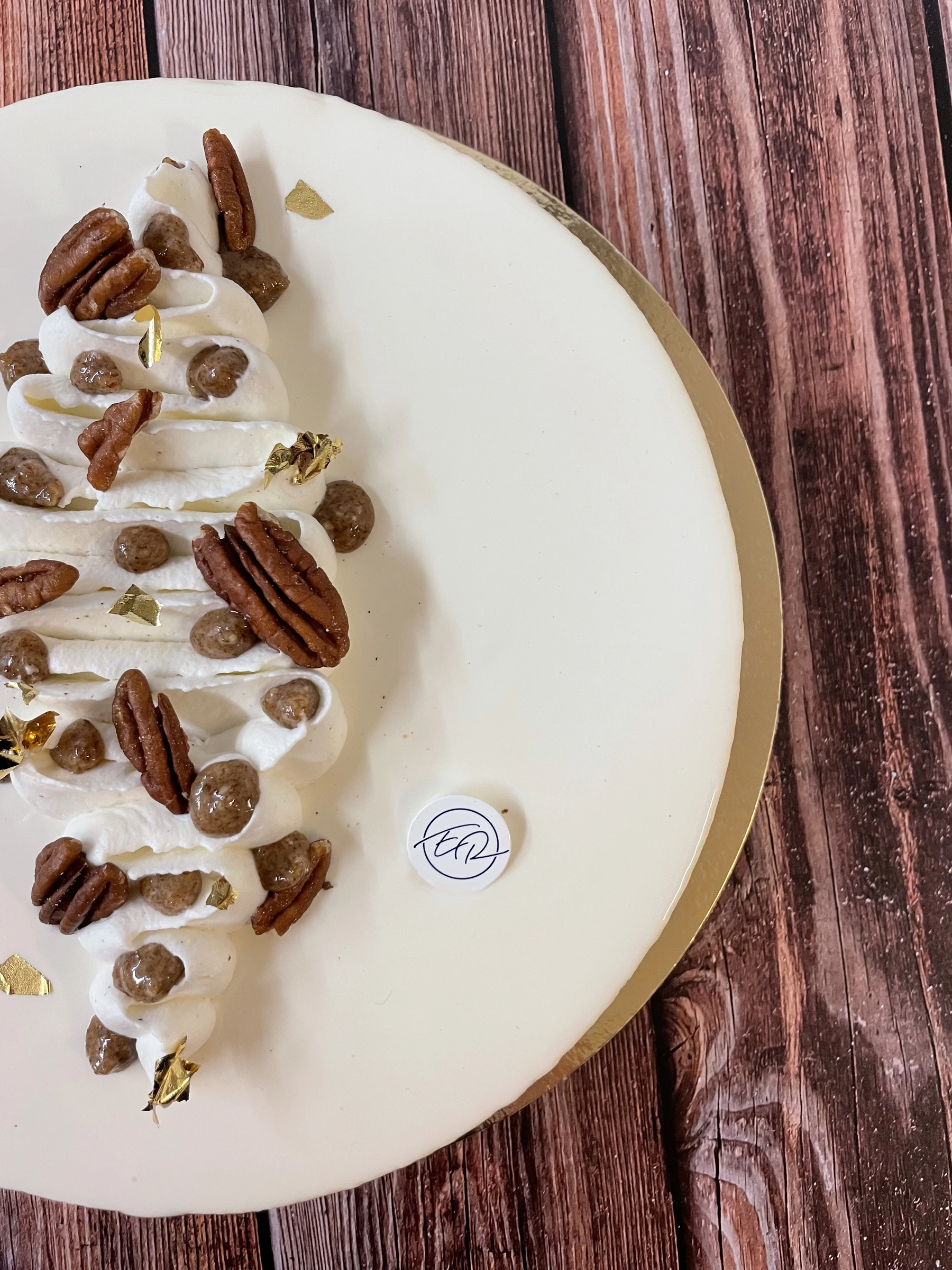 Gâteau blanc décoré de crème et de noix de pécan